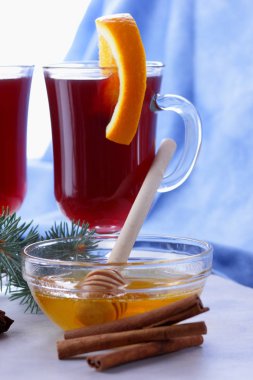 Noel mulled şarap portakal dilimleri, tarçın ve anason, içki bal ile ışık mavi ve beyaz arka plan üzerinde mulled şarap mulled şarap