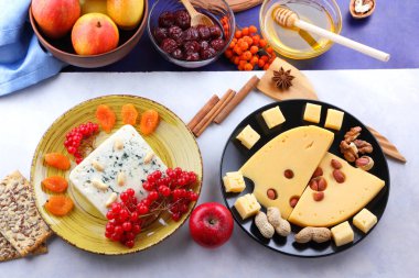 Peynir kalıp, meyve, koyu mavi zemin üzerine delikli sert peynir, siyah saç, meyve, fındık, bal, reçel, Noel yemeği, çok renkli arka plan, retro tarzı üzerinde peynir ile