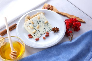 Beyaz bir plaka üzerinde bir kalıp ile tatlım, deli peynir, beyaz bir arka planda, yumuşak kırmızı meyveler fındık ile peynir Noel yemeği, minimalizm, retro tarzı için