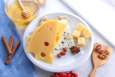 Kalıp peynir ve sert sarı peynir beyaz bir tabak, tatlım, fındık, kırmızı beyaz bir arka planda Noel yemeği, peynir arka plan, pop sanat için delikli peynir çilek