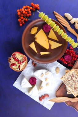 Peynir, yumuşak ve sert peynir, meyve, fındık, bal, Peynir tabağı koyu mavi arka plan, retro tarzı, pop art, vegan Kahvaltı