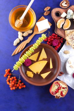 Peynir, yumuşak ve sert peynir, meyve, fındık, bal, Peynir tabağı koyu mavi arka plan, retro tarzı, pop art, vegan Kahvaltı