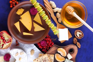 Peynir, yumuşak ve sert peynir, meyve, fındık, bal, Peynir tabağı koyu mavi arka plan, retro tarzı, pop art, vegan Kahvaltı