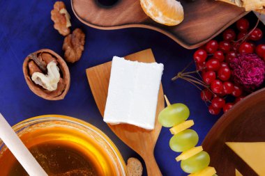 Peynir, yumuşak ve sert peynir, meyve, fındık, bal, Peynir tabağı koyu mavi arka plan, retro tarzı, pop art, vegan Kahvaltı