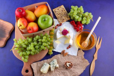 Camembert, kalıp, elma, Yeşil üzüm, bal, kırmızı meyveler kartopu, fıstık, koyu mavi arka plan, pop art, retro tarzı, armut, sağlıklı gıda, parşömen kağıt, ahşap masa, sanat üzerine kaşar peynir