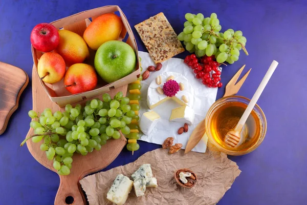 Camembert, kalıp, şenlikli Yemeği, elma, Yeşil üzüm, bal, kırmızı meyveler kartopu, fıstık, koyu mavi arka plan, pop art, armut, sağlıklı gıda, parşömen kağıt üzerine kaşar peynir