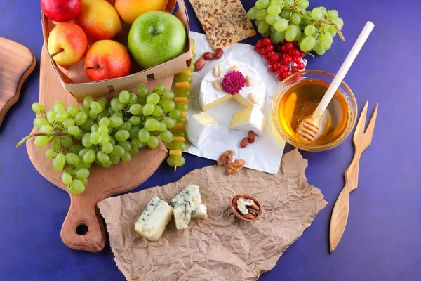 Camembert, kalıp, şenlikli Yemeği, elma, Yeşil üzüm, bal, kırmızı meyveler kartopu, fıstık, koyu mavi arka plan, pop art, armut, sağlıklı gıda, parşömen kağıt üzerine kaşar peynir
