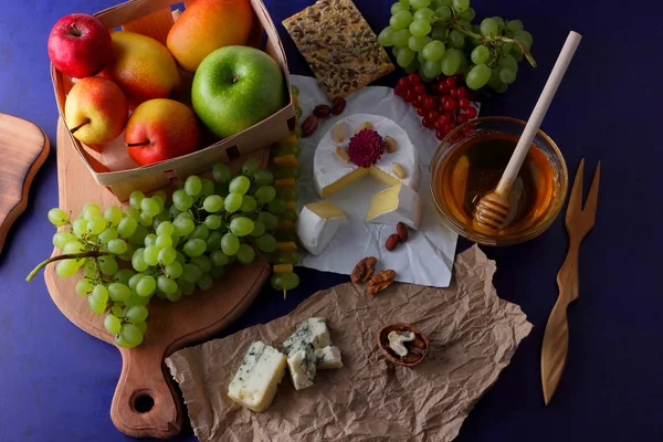 Camembert, kalıp, şenlikli Yemeği, elma, Yeşil üzüm, bal, kırmızı meyveler kartopu, fıstık, koyu mavi arka plan, pop art, armut, sağlıklı gıda, parşömen kağıt üzerine kaşar peynir