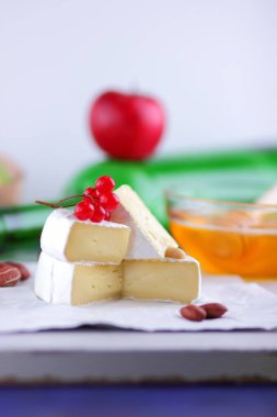 Brie peyniri ile Fransız Camembert Yeşil üzüm, bal brie peyniri ile arka plan, kırmızı meyveler ve pembe çiçek, fıstık, sağlıklı gıda yeşil şişe ile Kahvaltı
