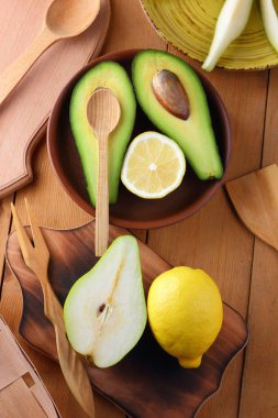 Avokado, limon ve armut ahşap zemin, sarı plaka ile armut dilimleri, ahşap tahta ve kutusu, avokado retro tarzı, ahşap arka plan ile meyve dilimlenmiş