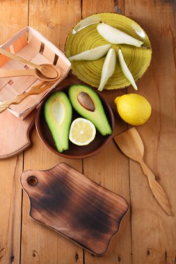 Avokado, limon ve armut ahşap zemin, sarı plaka ile armut dilimleri, ahşap tahta ve kutusu, avokado retro tarzı, ahşap arka plan ile meyve dilimlenmiş