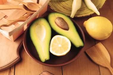 Avokado, limon ve armut ahşap zemin, sarı plaka ile armut dilimleri, ahşap tahta ve kutusu, avokado retro tarzı, ahşap arka plan ile meyve dilimlenmiş