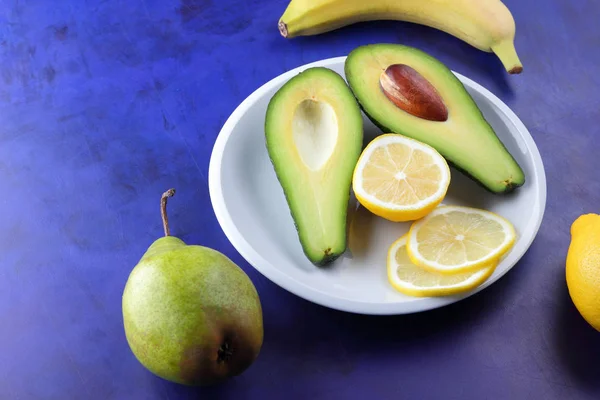 Aguacate Plátano Limón Pera Verde Plato Blanco Frutas Tropicales Fondo —  Fotos de Stock