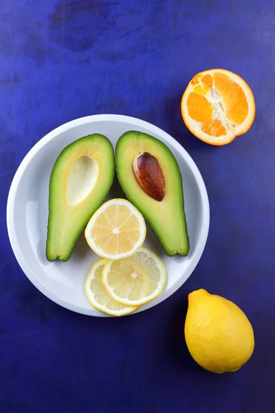 Aguacate Limón Media Naranja Plato Blanco Frutas Tropicales Sobre Fondo —  Fotos de Stock