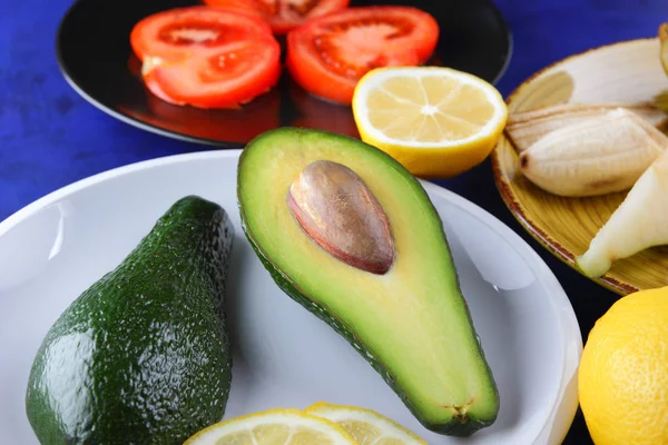 Aguacate Limón Plato Blanco Tomate Plato Negro Cítricos Sobre Fondo —  Fotos de Stock