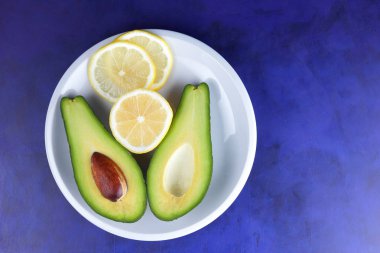 Dilim limon beyaz tabakta, tropik meyveler bir ultraviyole arka plan, vejetaryen Kahvaltı, Asya Mutfağı, avokado pop art, avokado, sanat narenciye ve avokado