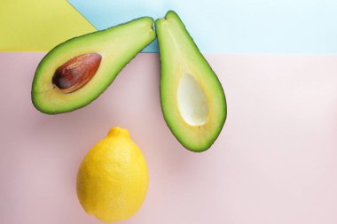 Avokado, limon ve yarım portakal renkli arka plan, tropikal meyve pop art, vejetaryen Kahvaltı, Asya Mutfağı, avokado pop art, narenciye, turuncu avokado ile