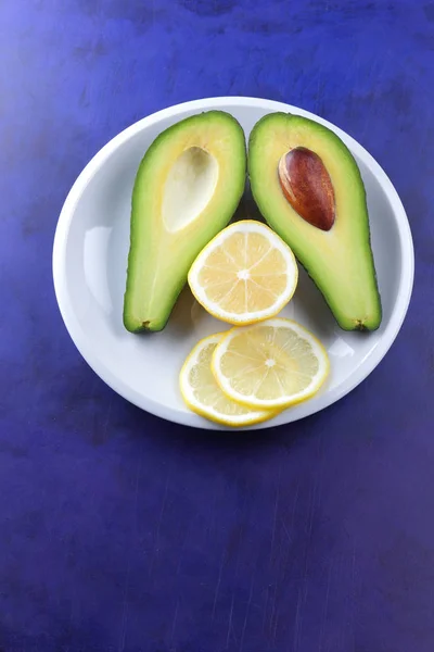 Αβοκάντο Και Φέτες Λεμονιού Ένα Άσπρο Πιάτο Τροπικά Φρούτα Μια — Φωτογραφία Αρχείου