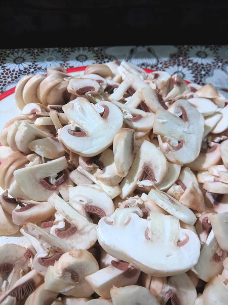 Sliced mushrooms on the board, champignons before cooking, mushrooms in the home kitchen, retro style, American cuisine, vegetarian food