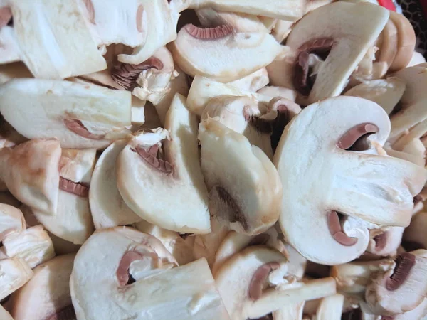 Sliced mushrooms on the board, champignons before cooking, mushrooms in the home kitchen, retro style, American cuisine, vegetarian food