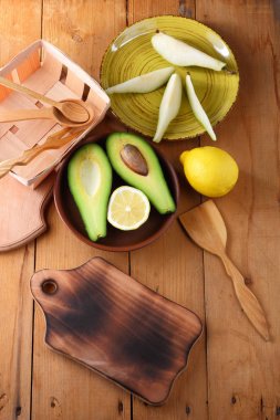 Avokado, limon ve bir ahşap arka plan, sarı plaka armut dilimleri, ahşap tahta ve kutusu, retro tarzı, ahşap arka plan ile meyve, dilimlenmiş avokado ile armut sanat