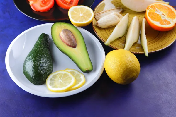 Aguacate Limón Plato Blanco Tomate Plato Negro Cítricos Sobre Fondo —  Fotos de Stock