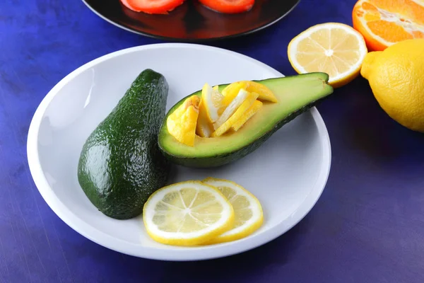 Avocado and lemon on a white plate, tomato on a black plate, citrus on an ultraviolet background, chopped banana and pear, avocado pop art, healthy food, vegan, retro style, pop art