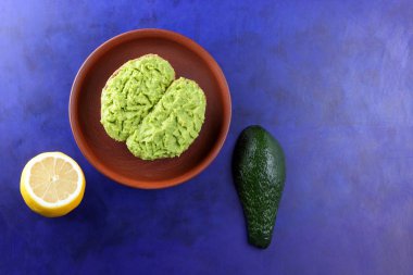 Avokado ve limon, avokado, yarım limon, vejetaryen yemek, sağlıklı gıda, Latin Amerika mutfağı ile yapılan sandviç yayılan ultraviyole arka planda, yeşil kil tabakta avokado ile yapıştırma