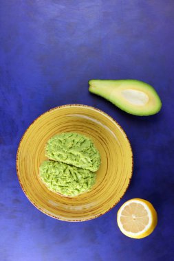 Avokado ve limon, yapıştırma sandviç yayılan ultraviyole arka planda, yeşil sarı bir plaka üzerinde avokado ile yapılan avokado, yarım limon, vejetaryen yemek, pop art, Latin Amerika mutfağı ile