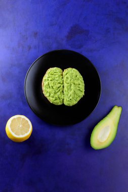 Avokado ve limon, sandviç yayılan ultraviyole arka planda, yeşil ile yapılan avokado, yarım limon, vejetaryen yemek, pop art, Latin Amerika mutfağı ile ekmek, siyah plaka üzerinde avokado Yapıştır