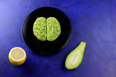 Avokado ve limon, sandviç yayılan ultraviyole arka planda, yeşil ile yapılan avokado, yarım limon, vejetaryen yemek, pop art, Latin Amerika mutfağı ile ekmek, siyah plaka üzerinde avokado Yapıştır