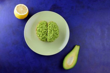 Avokado ve limon, sandviç yayılan ultraviyole arka planda, yeşil ile yapılan avokado, yarım limon, vejetaryen yemek, pop art, Latin Amerika mutfağı ile ekmek, yeşil plaka üzerinde avokado Yapıştır