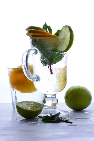 莫吉托与石灰和柠檬薄荷 鸡尾酒与冰在一个玻璃杯 软饮料与冰在一个轻的背景 空的空间 鸡尾酒流行艺术 色调背景 夏季饮料 — 图库照片