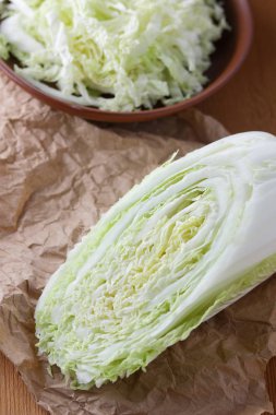 Lahana, rendelenmiş lahana ahşap arka plan, ev yemekleri, vejetaryen, taze sebze, rustik tarzı, Çin lahanası parşömen kağıt üzerinde üzerinde bir kil kase minimalizm