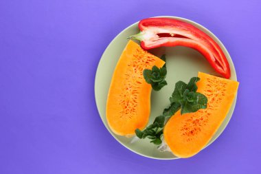 Mor bir arka planda bir kabak ve kırmızı biber yeşil bir tabak, sebze pop art, minimalizm, turuncu ve kırmızı sebze mor arka plan, Bulgar biber, vegan, sanat yarısı kabak