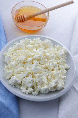 Beyaz arka plan, yumuşak peynir bir mavi peçete, tatlım, sağlıklı gıda, Fransız Kahvaltı, Amerikan mutfağı, minimalizm, süt ürünleri ile bal ile taze peynir lor keçi sütü ile