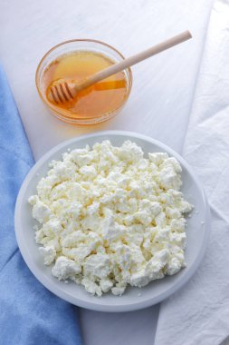 Beyaz arka plan, yumuşak peynir bir mavi peçete, tatlım, sağlıklı gıda, Fransız Kahvaltı, Amerikan mutfağı, minimalizm, süt ürünleri ile bal ile taze peynir lor keçi sütü ile