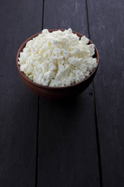 Taze peynir bir koyu ahşap arka plan, yumuşak peynir bir çanak çömlek, rustik tarzı, sağlıklı gıda, Fransız Kahvaltı, Amerikan mutfağı, minimalizm, kopya alanı süzme peynir süt ürünleri