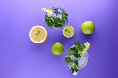 Mojito ultraviyole bir arka plan, nane, limon ve kireç, yaz dinlenmek için bir meşrubat, mor bir arka plan, bir pop sanat içki, yarım limon ve kireç, minimalizm kokteylde bir kokteyl