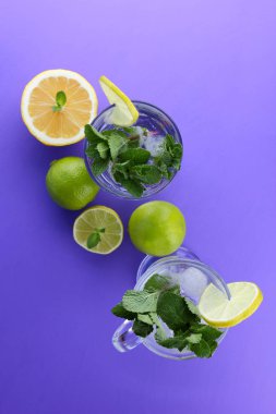 Mojito ultraviyole bir arka plan, nane, limon ve kireç, yaz dinlenmek için bir meşrubat, mor bir arka plan, bir pop sanat içki, yarım limon ve kireç, minimalizm kokteylde bir kokteyl