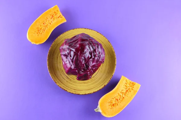 Purple cabbage on a yellow plate, cabbage and pumpkin on a purple background, minimalism, vegetables for vegan, sliced cabbage and half pumpkin pop art, fresh vegetables on salad, packaging design, art