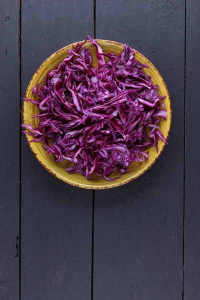 Sliced purple cabbage in clay pots, purple cabbage on a dark wooden background, sliced cabbage in the style of minimalism, vegetables in rustic style, vegetarian product, vitamins, healthy food