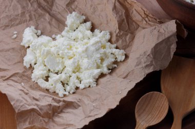 Peynir, peynir ve krem kil tencere, ahşap arka plan üzerinde taze peynir, ekşi krema rustik tarzı, sağlıklı gıda, Fransız Kahvaltı, üstten görünüm, parşömen kağıt, protein üzerinde keçi peyniri