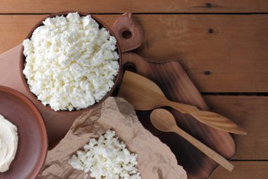 Peynir, peynir ve krem kil tencere, ahşap arka plan üzerinde taze peynir, ekşi krema rustik tarzı, sağlıklı gıda, Fransız Kahvaltı, üstten görünüm, parşömen kağıt, protein üzerinde keçi peyniri