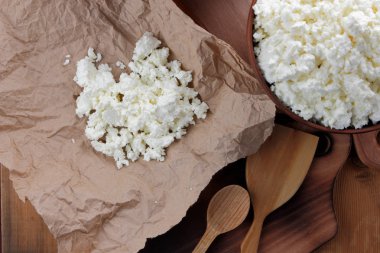 Peynir, peynir ve krem kil tencere, ahşap arka plan üzerinde taze peynir, ekşi krema rustik tarzı, sağlıklı gıda, Fransız Kahvaltı, üstten görünüm, parşömen kağıt, protein üzerinde keçi peyniri