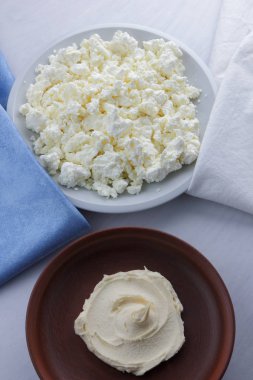 Peynir, peynir beyaz tabak, beyaz ve mavi peçeteye taze peynir, beyaz arka plan, sağlıklı gıda, Fransız Kahvaltı, üstten görünüm, keçi süt ürünleri lor minimalist tarzda, protein