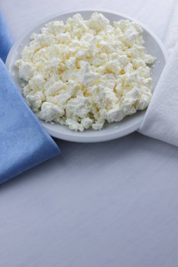 Peynir, peynir beyaz tabak, beyaz ve mavi peçeteye taze peynir, beyaz arka plan, sağlıklı gıda, Fransız Kahvaltı, üstten görünüm, keçi süt ürünleri lor minimalist tarzda, protein