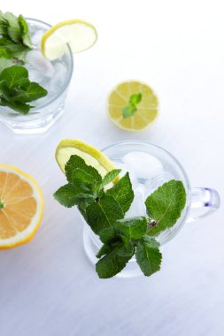 Beyaz bir arka planda mojito yaz tatili, buz ile kokteyl yumuşak bir içki kireç ve limon, taze nane bir içki, minimalizm, bir tasarımcı için hazırlık yapmak için bir kokteyl, narenciye için