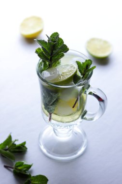 Beyaz bir arka planda mojito yaz tatili, buz ile kokteyl yumuşak bir içki kireç ve limon, taze nane bir içki, minimalizm, bir tasarımcı için hazırlık yapmak için bir kokteyl, narenciye için