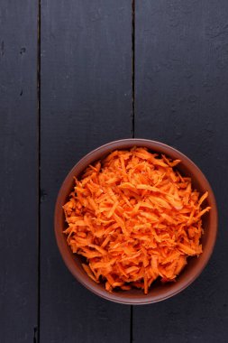 Kil tencere, koyu ahşap zemin, turuncu havuç rendelenmiş havuç rendelenmiş havuç minimalizm tarzı, rustik sebze, vejetaryen ürün, vitaminler, sağlıklı gıda, sanat